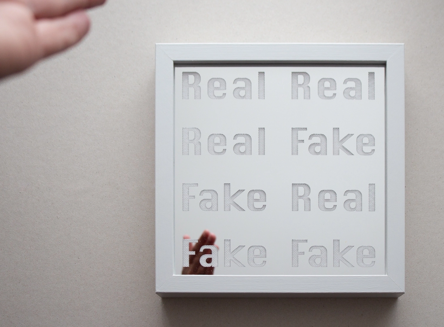 A mirror with the words real and fake etched into it